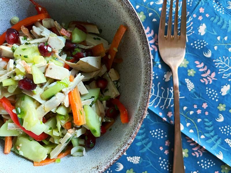 Bunter Salat mit Räuchertofu, Gurke, Karotte, Paprika und Cranberries in einer Keramikschale